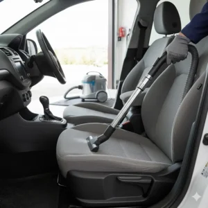 Using a wet and dry vacuum attachment to deep clean car carpets and fabric seats.