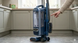 A Shark upright vacuum cleaner showing the crevice tool and upholstery brush stored neatly on the unit’s onboard storage clips.