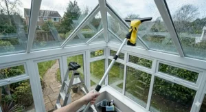 A window vacuum fitted with an extension pole to clean high-up conservatory windows.