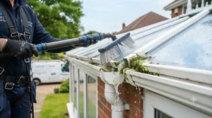 Close-up of a conservatory roof cleaner removing stubborn moss and algae from UPVC roof panels.