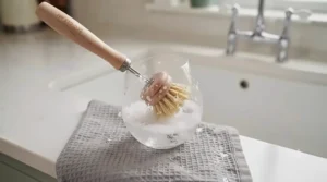 Collection of bamboo washing-up brushes and plant-based pot scrapers for zero-waste kitchen cleaning.