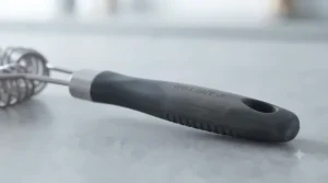 An ergonomic, long-handled wire-free barbecue cleaning brush designed for comfortable grip during heavy-duty cleaning.